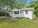 Charming white brick home featuring a carport, black trim, and a manicured front yard at 130 Oakcliff Court, Atlanta, GA 30331