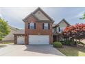 Charming brick and siding home with a well-manicured lawn and a two-car garage at 230 Wild Barley Way, Loganville, GA 30052