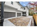 Exterior view of a white house with three-car garage and a spacious driveway with decorative pavers at 779-B Lynwood Se St, Atlanta, GA 30312