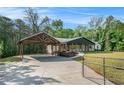 Scenic view of a home with a covered carport, well-manicured lawn, and gated entrance at 5035 Villa Rica Hwy, Dallas, GA 30157