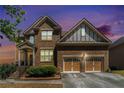 Beautiful two-story brick home with a two-car garage, landscaped yard, and evening sky at 1057 Cotton Oak Dr, Lawrenceville, GA 30045