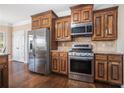 Kitchen with stainless steel appliances, wooden cabinets, granite countertops, and hardwood floors at 1057 Cotton Oak Dr, Lawrenceville, GA 30045