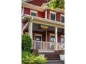 Inviting front porch with brick steps, white railing, stylish light fixtures and ceiling fans at 604 Mead Se St, Atlanta, GA 30312