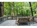 Comfortable outdoor seating on a cozy deck provides relaxing views of a wooded back yard at 111 John Christopher Dr, Alpharetta, GA 30009