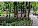 Lovely home nestled among the trees with a circular seating area and a long driveway at 111 John Christopher Dr, Alpharetta, GA 30009