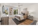 Serene main bedroom showcasing a tufted headboard, hardwood floors, and large windows at 1237 Memorial Se Dr # 404, Atlanta, GA 30316
