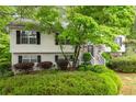 Inviting two-story house with well-maintained landscaping, complemented by dark shutters and a stone entryway at 174 Cannon Pl, Dallas, GA 30157