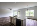 Open-concept kitchen with a spacious island, granite countertops, and modern lighting fixtures at 1810 Forkview Ct, Lawrenceville, GA 30044