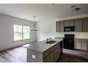 Well-lit kitchen featuring an island with a sink and stainless steel appliances at 1810 Forkview Ct, Lawrenceville, GA 30044