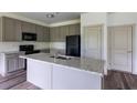 Modern kitchen features gray cabinets, granite countertops, and stainless steel appliances at 1810 Forkview Ct, Lawrenceville, GA 30044