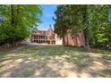 Expansive backyard with mature trees surrounding the property, and a brick exterior with screened in porch at 4835 Merlendale Ct, Atlanta, GA 30327