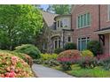 Close up of brick home with stone accents, beautiful landscaping, mature trees, and well-maintained flower beds at 4835 Merlendale Ct, Atlanta, GA 30327