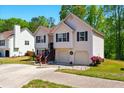 Beautiful split-level house boasting a well-kept lawn, vibrant flower bushes, and a convenient two-car garage at 1010 Augusta Woods Dr, Douglasville, GA 30134
