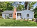 Charming blue home with a brick chimney, new landscaping, and a lush green lawn in a peaceful neighborhood at 1541 Pontiac Se Pl, Atlanta, GA 30315