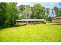 Charming brick home on a sunny day with a lush front yard, well-maintained landscaping, and a clear sky at 3047 E Anderson E Dr, Lithia Springs, GA 30122