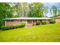 Lovely single-story brick home with a lush front yard, trimmed bushes, and classic black shutters at 3047 E Anderson E Dr, Lithia Springs, GA 30122