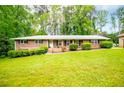 Inviting brick home with manicured landscaping, and a well-kept lawn on a sunny day at 3047 E Anderson E Dr, Lithia Springs, GA 30122