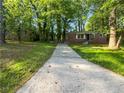 View of the home from driveway framed by mature trees in yard, showing facade, foundation, and mailbox at 233 Banberry Se Dr, Atlanta, GA 30315