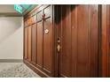 Apartment front door featuring rich wood paneling, hardware, and an 'Exit' sign overhead in hallway at 77 Peachtree Ne Pl # 107, Atlanta, GA 30309
