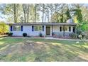 Welcoming single-Gathering home featuring a charming porch and lush green lawn at 1824 Guardian Way, Lawrenceville, GA 30043