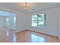 Elegant dining room with hardwood floors, crown molding, chandelier, and a large window at 2869 Hickory Run Cir, Duluth, GA 30096