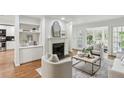 Bright living room features a fireplace and French doors that open to an outdoor view and access to kitchen at 3794 Ashford Lake Ne Ct, Brookhaven, GA 30319