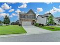 Beautiful two-story home with stone accents, a spacious driveway, and a lush green lawn at 4215 Cordova Ln, Cumming, GA 30028