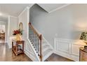 Elegant foyer featuring hardwood floors, a staircase with wooden railing, and wainscoting at 4215 Cordova Ln, Cumming, GA 30028