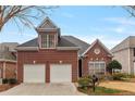 Charming two-story brick home with a two-car garage and manicured lawn at 6275 Glen Oaks Ln, Atlanta, GA 30328