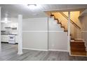 Renovated basement with kitchenette area, grey vinyl flooring, stairs to the upper level, and freshly painted walls at 6470 Sherwood Trl, Austell, GA 30168