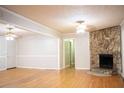 Inviting living area featuring a stone fireplace and hardwood floors, creating a cozy and stylish atmosphere at 6470 Sherwood Trl, Austell, GA 30168
