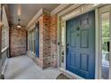 Inviting entryway featuring a classic blue front door, brick facade, and covered porch at 2725 Monet Dr, Cumming, GA 30041