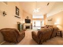 Inviting living room with a cozy fireplace, plush seating, a ceiling fan, and abundant natural light at 310 Morning Glen Dr, Suwanee, GA 30024