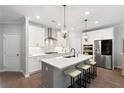 Modern kitchen with white cabinets, stainless steel appliances, a large island, and pendant lighting at 409 Retreat Ln, Canton, GA 30114