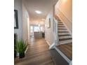 Hallway features hardwood floors, leading to kitchen and staircase with white railing at 1412 Shelnutt Ct, Hampton, GA 30228