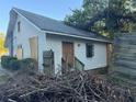 Rear of the house with a door, chimney, siding, and piles of debris at 29 Park Ne Cir, Atlanta, GA 30305