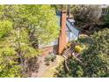 Aerial view of backyard with a brick chimney, tiered landscaping, and a lush, green lawn at 3485 Aubusson Trce, Johns Creek, GA 30022
