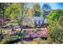 Beautifully landscaped yard surrounds this brick home with orange front door and an inviting curb appeal at 3485 Aubusson Trce, Johns Creek, GA 30022