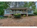 Charming single-story home features a covered porch, brick foundation, and mature landscaping at 5873 Trellis Ct, Powder Springs, GA 30127