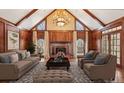 Elegant living room featuring wood paneled walls, a fireplace, and stylish furnishings under a vaulted ceiling at 2975 Coles Way, Atlanta, GA 30350