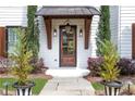 Close-up of a stylish front door with a covered porch, wooden accents, and elegant landscaping at 3920 Cash Lndg, Marietta, GA 30066