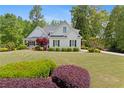Charming two-story home with manicured lawn, mature shrubs, and a driveway leading to a two-car garage at 109 Hawks Bnd, Canton, GA 30115