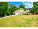 Single-story home with an attached garage and large front yard with lush landscaping at 2400 Honey Ct, Mcdonough, GA 30252