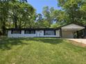 Well-maintained home featuring a lush lawn, shade trees, carport, and updated exterior paint at 2401 Winshire Drive, Decatur, GA 30035