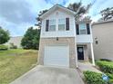 Charming two-story home with gray siding, brick accents, a single car garage, and a well-manicured lawn at 2365 Hackamore Dr, Atlanta, GA 30349
