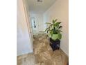 Hallway featuring neutral tile flooring, white walls, and a decorative potted plant on a black table at 2365 Hackamore Dr, Atlanta, GA 30349