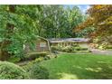 Beautiful front yard with mature trees and manicured landscaping surrounding this brick and siding ranch style home at 4293 Smithsonia Dr, Tucker, GA 30084