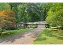 Beautiful front yard with mature trees, a brick driveway, and manicured landscaping surrounding this ranch style home at 4293 Smithsonia Dr, Tucker, GA 30084