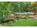Well-manicured lawn and garden beds lead to this ranch-style home with brick and siding and a brick driveway at 4293 Smithsonia Dr, Tucker, GA 30084
