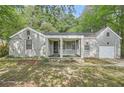 Charming one-story home with brick facade, covered porch, attached garage and mature trees at 1723 Ritcherson Se St, Marietta, GA 30060
